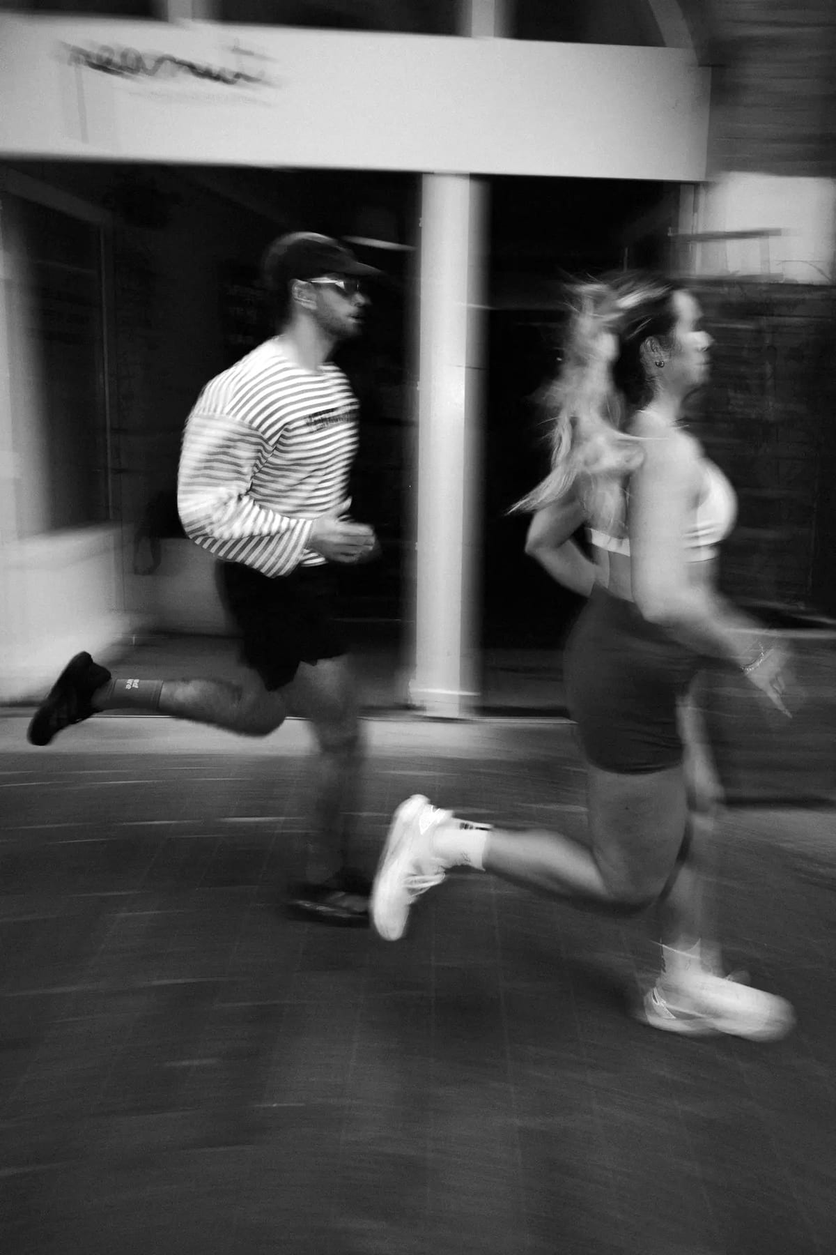 Deux coureurs du club passent en filé devant le café Peanut, à Toulouse